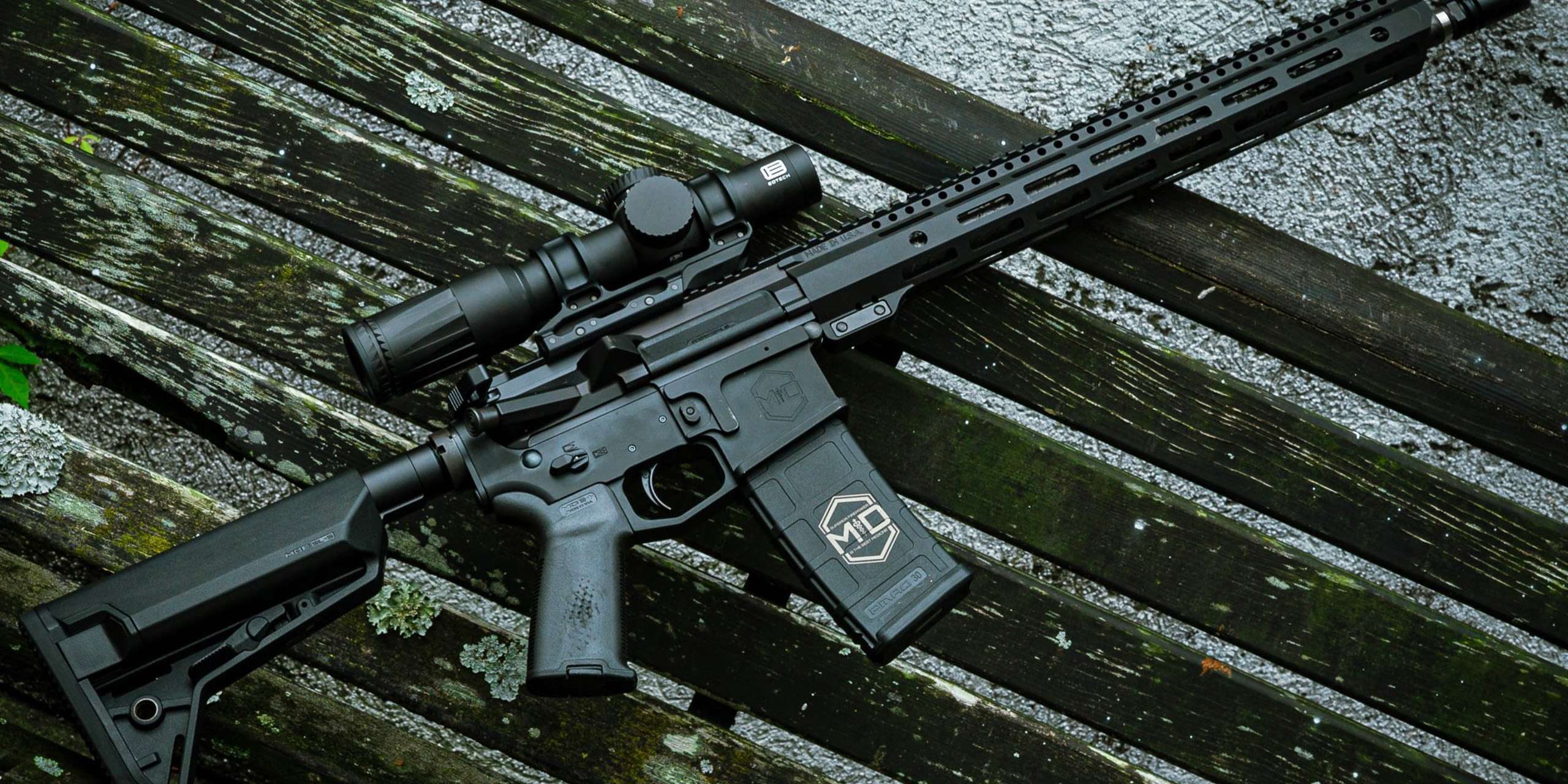 TheDoc_mainpage SOIDC DOC AR15 with scope leaned against wood bench